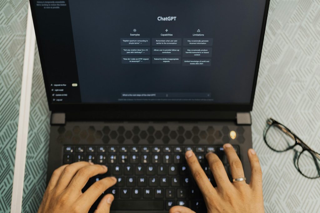 Hands typing on a laptop with ChatGPT open, illustrating AI tools in modern SEO strategy